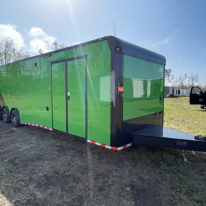 Rock Solid Cargo 8.5x36 enclosed race car trailer with Lucky Green and black polycore exterior, triple torsion axles, escape door, electric awning, cabinets, and E-track flooring for sale.