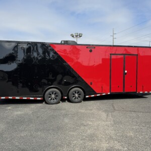 8.5x28 tandem axle race trailer with red under glow lights, blackout package, torsion spread axles, cabinets, E-Track, winch, and air conditioning