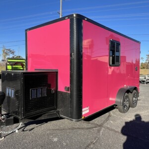 Pink Genesis Series 7x12 pet grooming trailer with blackout trim, Flying Pig tub, generator box, water tanks, cabinets, and air conditioning.