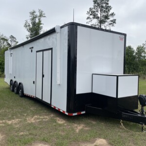 Rock Solid Cargo 8.5x34 triple axle race car trailer with white exterior, spread torsion axles, electric awning, generator compartment, RTP flooring, and premium race package.