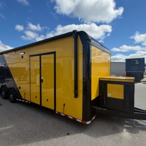 Rock Solid Cargo 8.5x28 enclosed race car trailer with yellow and black two-tone exterior, blackout package, spread torsion axles, escape door, generator compartment, and electric awning.