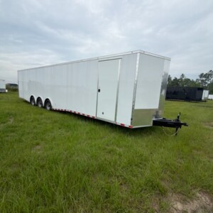 8.5x36 triple axle enclosed double car hauler trailer with Poly exterior, semi-screwless finish, dual escape doors, D-rings, spread axles, and ATP fenders.