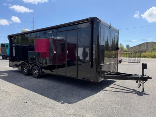 Freedom Cargo 8.5x24 race car trailer with black Polycore exterior, blackout package, spread torsion axles, electric awning, escape door, cabinets, and air conditioning.