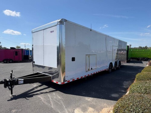 White and silver 8.5x34 enclosed race car trailer with tandem axles, race package, cabinets, E-Track tie-downs, and premium hauling features.