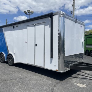 Freedom Cargo 8.5x24 race car trailer with white and blue Polycore exterior, spread axles, electric awning, escape door, cabinets, and air conditioning.