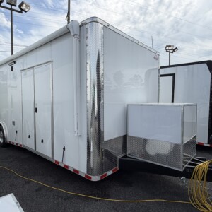 Rock Solid Cargo 8.5x28 enclosed race car trailer with white exterior, spread torsion axles, escape door, electric awning, generator compartment, and premium race package.