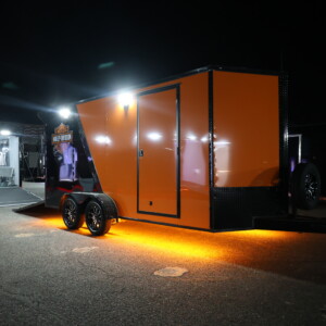 orange and black motorcycle trailer with harley decals and lights