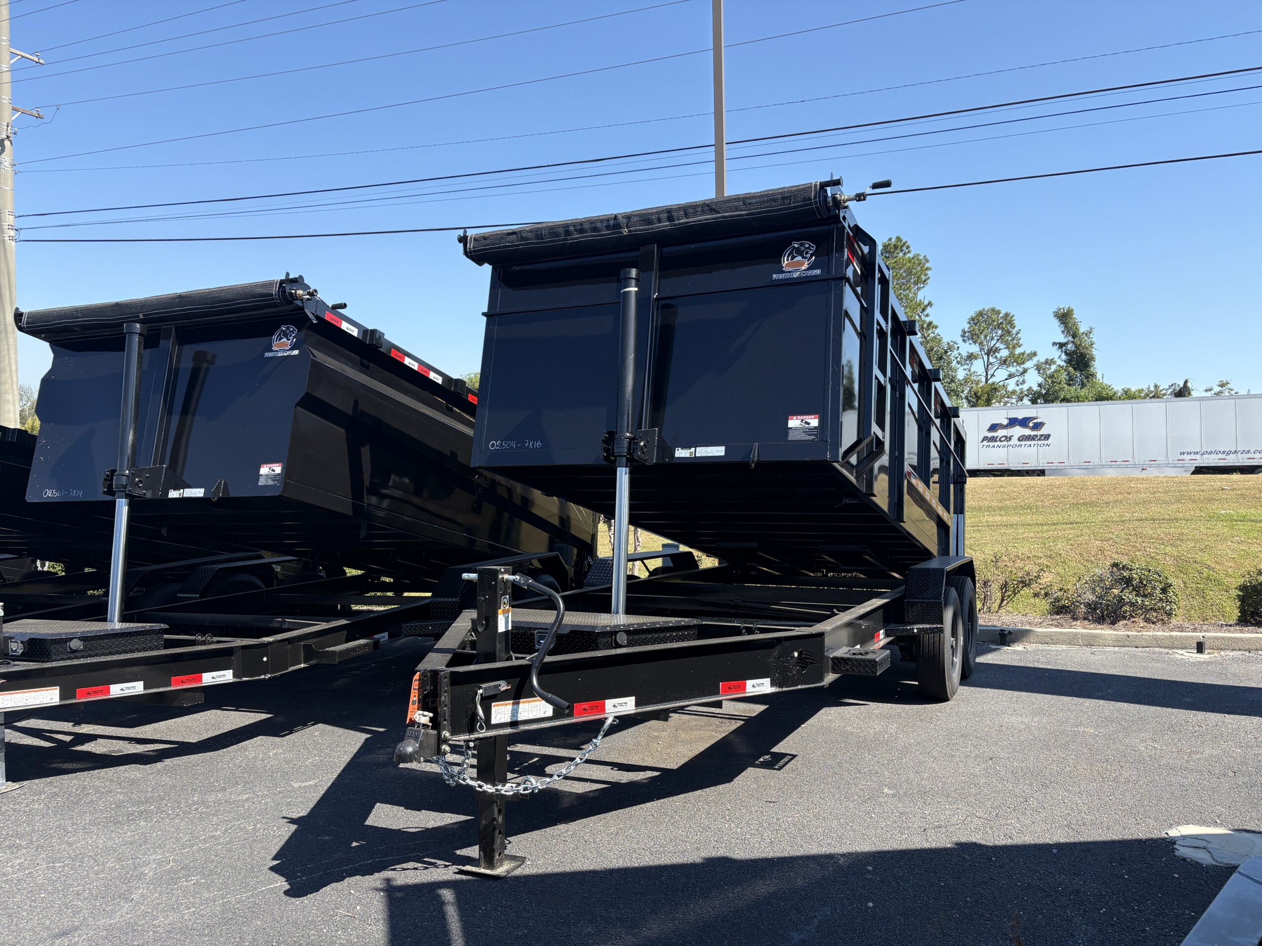 Black Panther Cargo 7x16 tandem axle dump trailer with 4-foot steel walls, heavy-duty steel dump bed, rear barn doors and tarp system.
