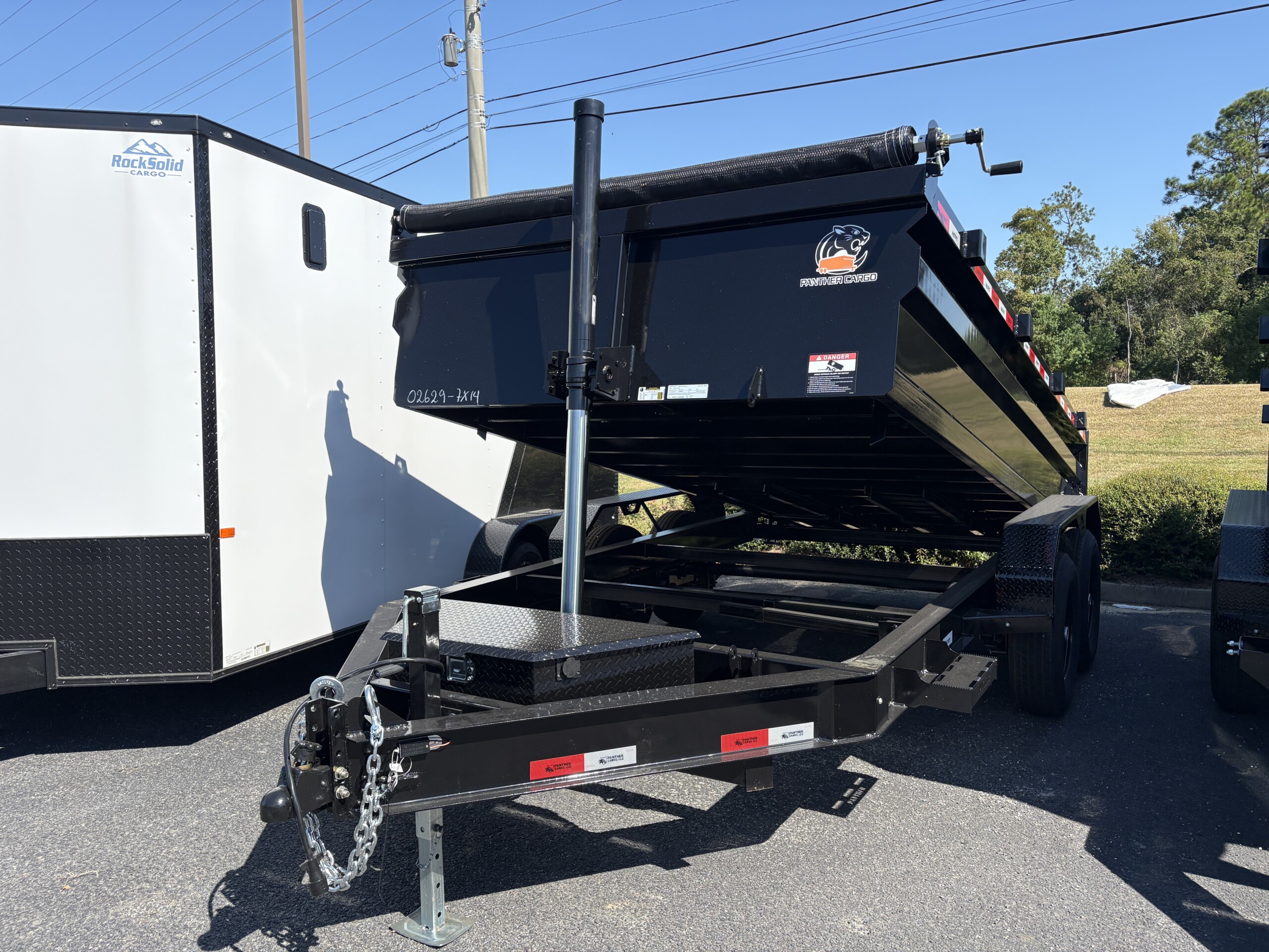 Panther Cargo 7x14 tandem axle 14K dump trailer with 2-foot steel sides, heavy-duty steel dump bed, rear barn doors and tarp system.